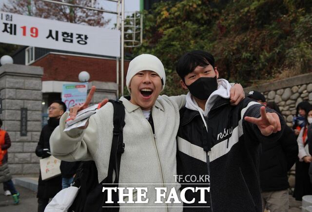 강도검 군과 김건우 군이 시험장 앞에서 활짝 웃고 있다.