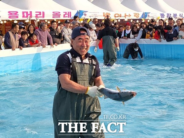 그놈 착 묵직하구만… 최남단 방어축제가 23일 서귀포시 모슬포항 일원에서 시작한 가운데 맨손 방어잡기 참가자가 방어를 잡고 미소를 띄고 있다./서귀포시=허성찬기자