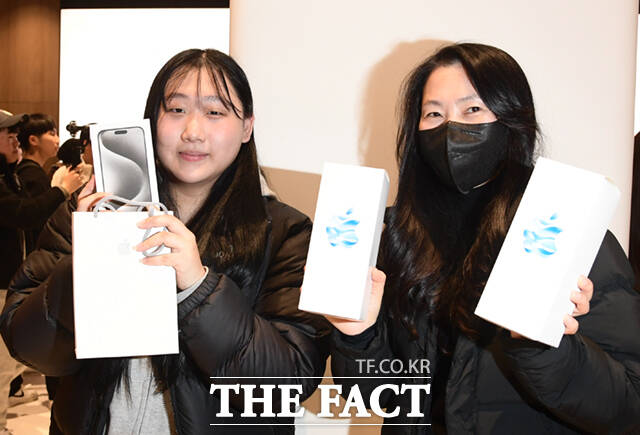 애플 하남 매장의 아이폰 첫 구매자인 김가은 양(왼쪽)과 어머니가 제품을 든 채 포즈를 취하고 있다.
