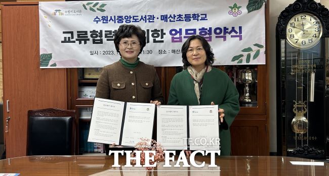 수원중앙도서관과 매산초등학교 관계자가 14일 매산초등학교에서 독서문화 기반 조성 등을 위해 협약을 맺고 있다./수원시