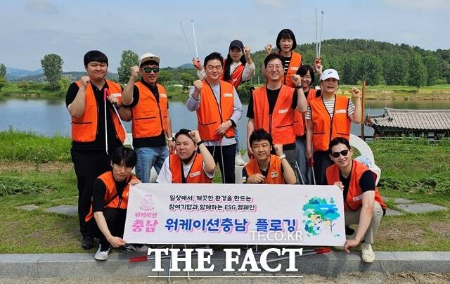 충남 워케이션 참가자들이 부여 백마강에서 플로깅 활동 후 기념 촬영을 하고 있다. / 충남도