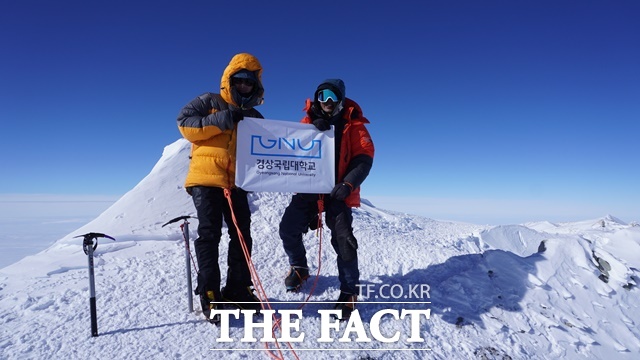 경상국립대학교 산악회가 세계 7대륙 최고봉 마지막으로 남아 있는 남극 최고봉 빈슨산(4892m) 등정에 성공했다. 남극 정상에서 경상국립대학교 교기를 들고 문성진 대장(왼쪽)과 문성현 대원이 사진을 찍고 있다./경상국립대