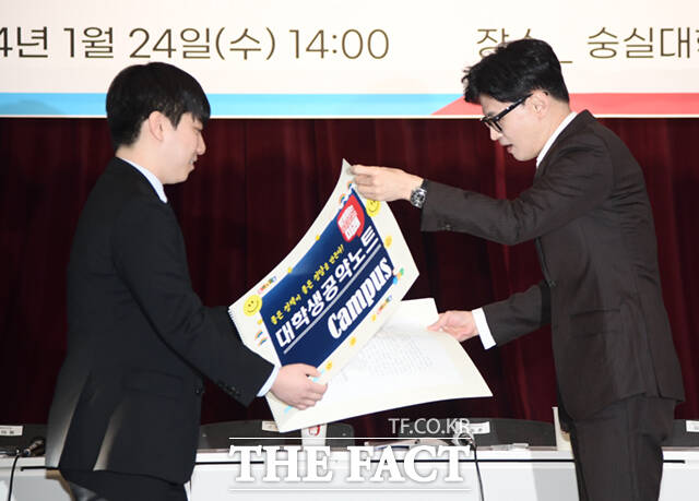한동훈 국민의힘 비상대책위원장(오른쪽)이 김재수 서울권대학생협의회 의장으로부터 대학생 공약노트를 전달받고 있다.