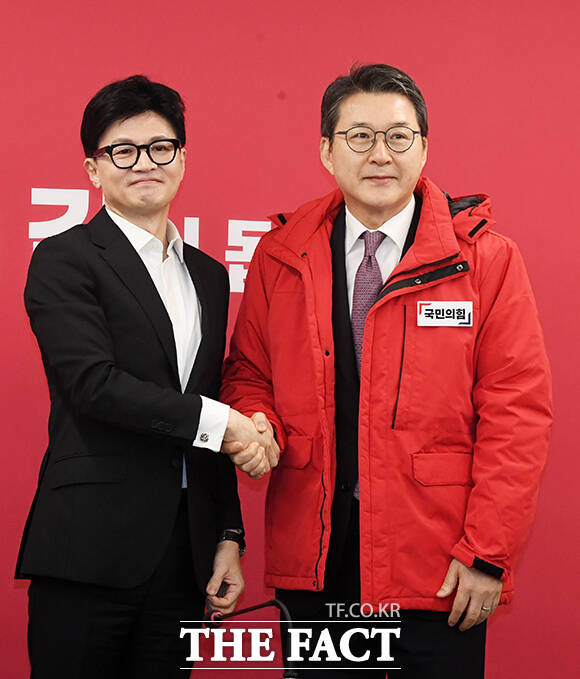 신동욱 전 TV조선 앵커에게 빨간색 점퍼를 선물하는 한동훈 위원장(왼쪽).