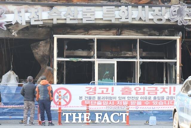 화재로 검게 탄 서천특화시장을 지나가던 상인들이 바라보고 한숨을 내쉬고 있다. / 서천=김아영 기자