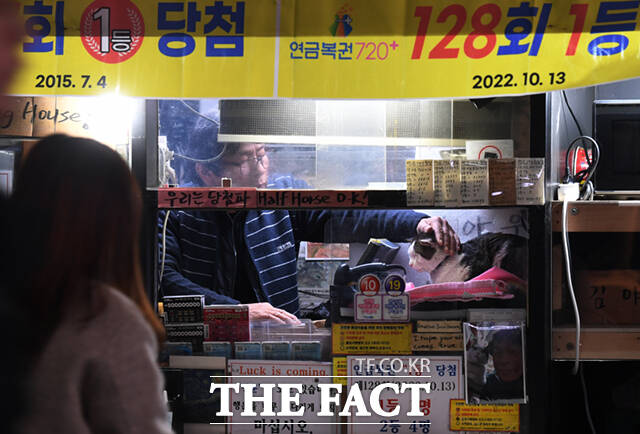 13일 오후 서울의 한 지하철역 앞 복권판매점에 출근한 길고양이 야웅이가 사장 김원장 씨와 함께 가게를 지키고 있다. /이새롬 기자