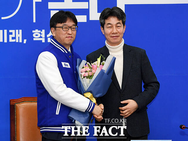 이용우 변호사(왼쪽)에게 꽃다발 선물하는 윤건영 의원.