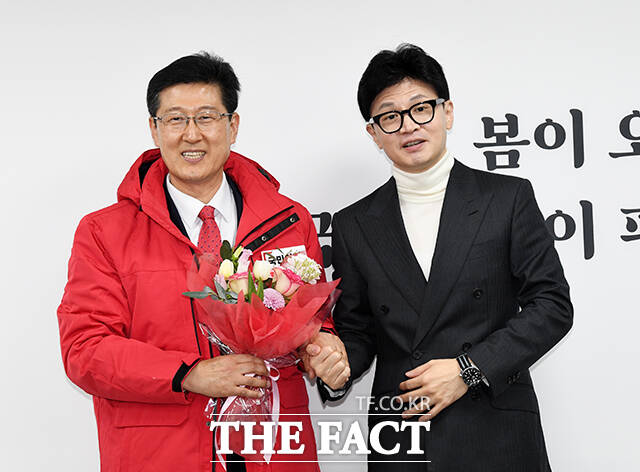 김인현 고려대학교 법학전문대학원 교수(왼쪽)에게 당 점퍼와 꽃다발을 선물하는 한동훈 위원장.