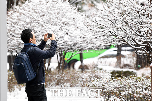 전국 대부분의 지역에 비나 눈이 내리는 22일 오전 서울 마포구 상암동 일대의 시민이 출근길 발걸음을 멈추고 쌓인 눈을 찍고 있다. /서예원 기자