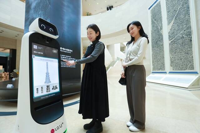 LG유플러스 모델들이 서울 용산구 국립중앙박물관에서 U+안내로봇의 설명을 듣고 있다. /LG유플러스