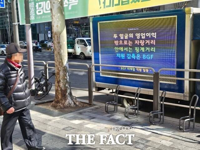 지난달 26일 오후 서울 강남구 BGF리테일 본사 앞에 직원들이 트럭시위를 시작한 가운데, 한 시민이 전광판을 바라보고 있다. /우지수 기자