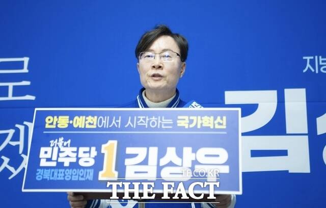 김상우 예비후보가 피켓을 들고 서 있다.