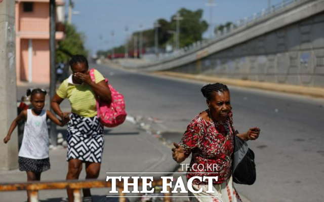 6일(현지시각) 아이티 포르토프랭스에서 주민들이 경찰과 갱단의 충돌을 피해 달아나고 있다. / AP.뉴시스