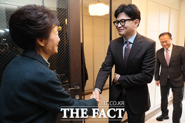박근혜 전 대통령(왼쪽)과 악수하는 한동훈 위원장.