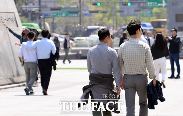 겉옷은 허리에 서울 광화문 광장을 찾은 시민들이 겉옷을 벗은 채 이동하고 있다.