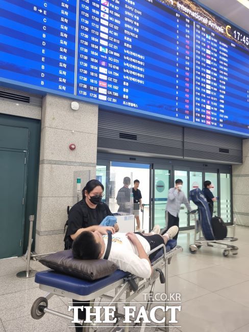 지난 25일 인천국제공항 입국장에서 한 성남시민이 환자 이송 침대에 누워 입국하고 있다./성남시
