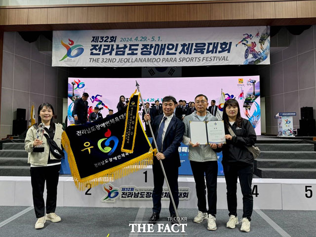 강우연(사진 왼쪽에서 두 번째) 여수시장애인체육회 상임부회장이 우승기를 들고 있다. / 여수시