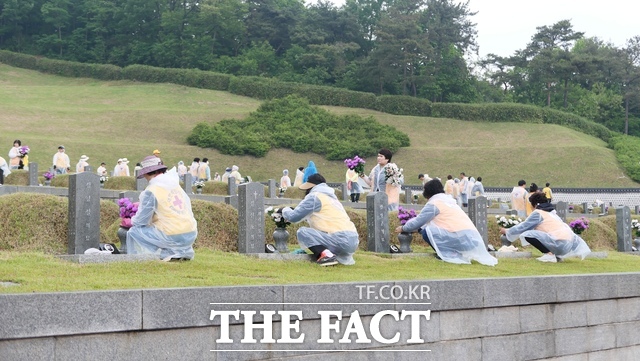 대한적십자사 광주전남지사가 국립 5⋅18민주묘지에서 회원 170여 명이 참여한 가운데 묘비닦기와 조화교체 봉사활동을 했다. 사진은 적십자 봉사자들이 조화를 교체하고 있는 모습/ 대한적십자사 광주전남지사