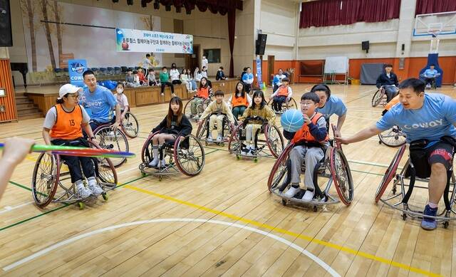 지난 7일 경기도 남양주시 평내초등학교에서 코웨이 블루휠스 휠체어농구단이 4학년 학생들과 휠체어농구 체험교실 프로그램을 진행하고 있다. /코웨이