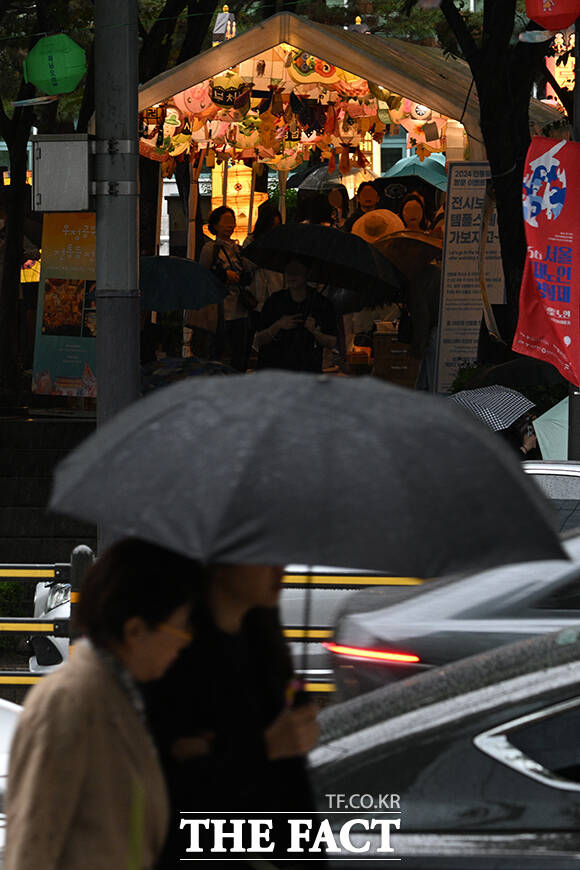 어린이 날에 이어 부처님 오신 날까지 연휴마다 비가 내리고 있다. 사진은 우산을 쓴 시민 너머로 조계사를 찾은 불자들이 연등을 관람하는 모습.