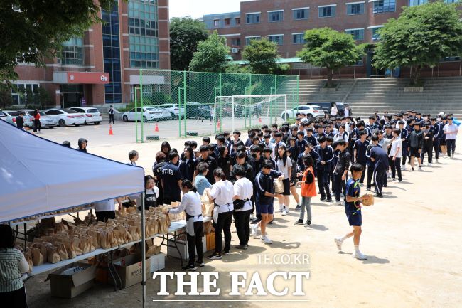 수원시자원봉사센터와 수원FC위민 선수단이 27일 삼일공업고등학교에서 사랑의 밥차 활동을 하고 있다./수원시자원봉사센터