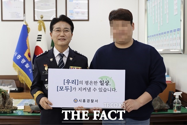 김신조 시흥경찰서장(왼쪽)이 정민수 씨에게 감사장 등을 전달하고 기념촬영을 하고 있다. /경기남부경찰청 제공