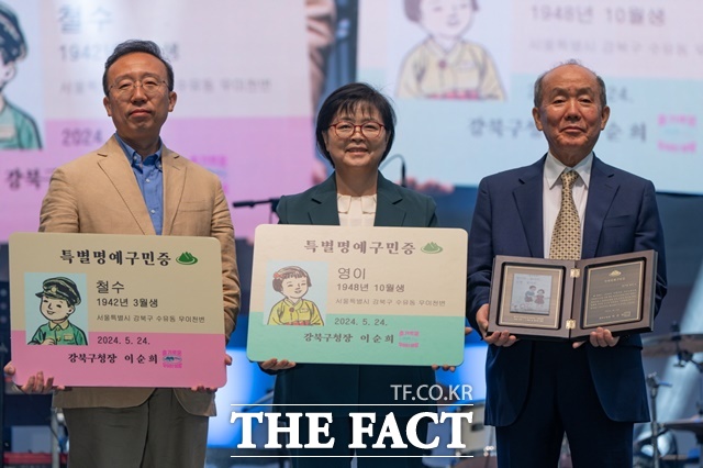 이순희 강북구청장이 24일 김주영씨에게 철수와 영이 특별 명예구민증을 수여한 뒤 기념사진을 찍고 있다. /강북구