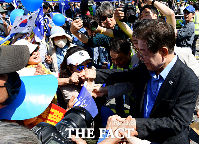 이재명 더불어민주당 대표(오른쪽)가 지난 1일 오후 서울 중구 서울역 인근에서 열린 윤석열 정권 규탄 및 해병대원 특검법 관철을 위한 범국민대회에 참석해 한 지지자에게 손등 키스를 받고 있다. /배정한 기자