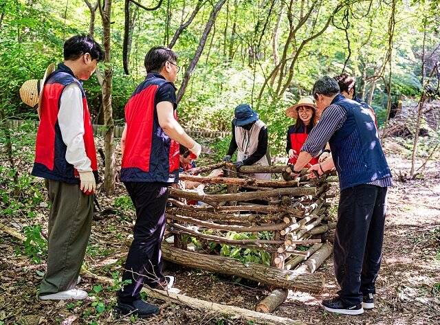 지난달 21일 성남시 분당구 야탑동 맹산반딧불이생태원에서 네오위즈홀딩스와 네오위즈 임직원들이 비오톱 조성 활동에 참여하고 있다. /네오위즈