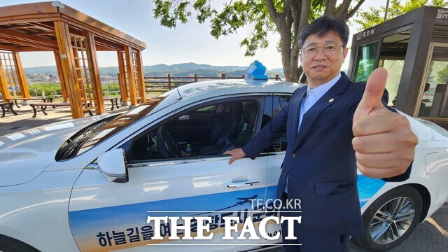 서대식 대구시 군위군의회 부의장이 저녁이면 몰고 다니는 택시 앞에서 엄지를 치켜들고 포즈를 취했다./군위=김민규 기자