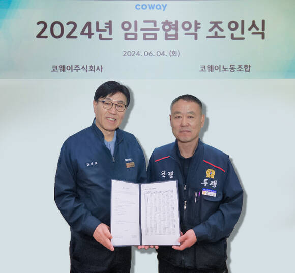 지난 4일 충청남도 공주시 유구공장에서 열린 2024년 임금협약 조인식에서 김동화 코웨이 생산본부장(왼쪽)과 임재환 생산 코웨이노동조합 위원장이 기념 촬영하고 있다. /코웨이