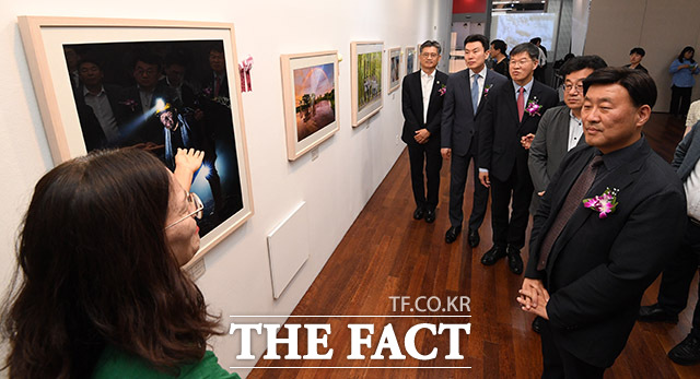 더팩트 사진전 대상 수상자인 김미영 씨(왼쪽)가 내빈들에게 작품 설명을 하고 있다.