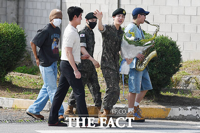 그룹 방탄소년단(BTS)의 진(가운데)이 12일 오전 경기 연천 제5보병사단 신병교육대에서 전역한 뒤 부대를 나오면서 팬들을 향해 인사하고 있다. /연천=장윤석 기자