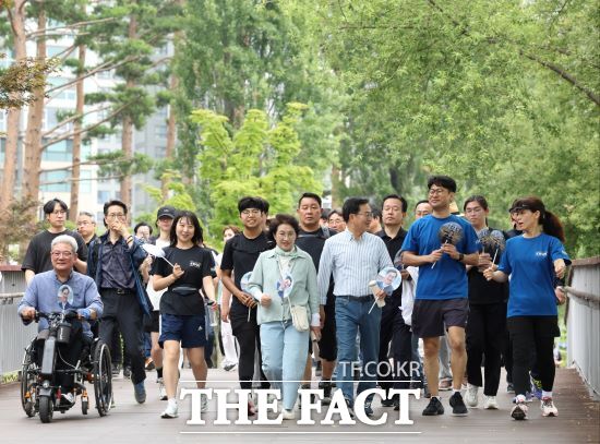 김동연 경기도지사는 15일 시민들과 함께 광교 호수공원 길을 걸으며 대화를 나누고 있다./경기