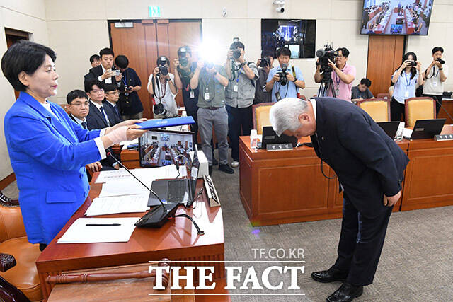 최민희 과방위원장(왼쪽)에게 선서문을 제출하는 김홍일 위원장 뒤로 국민의힘 의원의 빈자리가 보이고 있다.