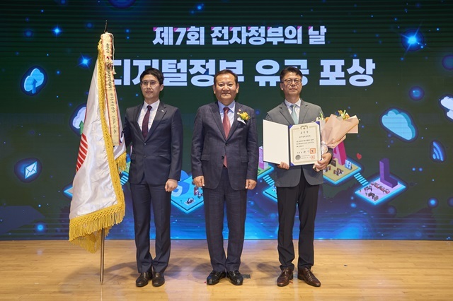 김승현 동서발전 정보보안처장(오른쪽)이 이상민 행정안전부 장관(가운데)으로부터 공공데이터 발전 유공 대통령상 받은 후 기념 촬영을 하고 있다. /한국동서발전