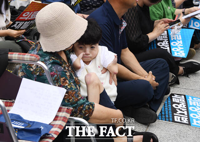 한국환자단체연합회와 한국유방암환우총연합회, 한국희귀·난치성질환연합회원들이 4일 오전 서울 종로구 보신각 앞에서 열린 의사 집단휴진 철회 및 재발방지법 제정 환자촉구대회에서 구호를 외치는 가운데, 코넬리아드랑게 증후군을 앓는 박하은 씨와 어머니가 함께 집회에 참여하고 있다. /이새롬 기자