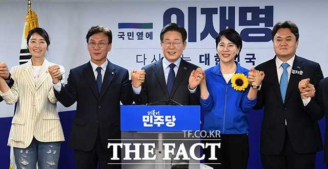 이날 당대표 연임 도전을 선언한 이재명 전 대표가 강선우, 김민석 의원, 전현희 의원, 김지호 부대변인(왼쪽부터)과 손을 잡고 있다.