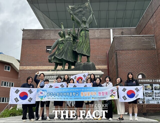 광주수피아여자중학교 학생들이 17일 강원도 고성, 양구 등에서 진행되는 글로벌 리더 팔도 한바퀴에 나서기 전 광주수피아여고 3·1운동 상 앞에서 탐방 성공을 기원하는 현수막과 태극기를 들고 단체사진을 찍고 있다/ 광주광역시교육청