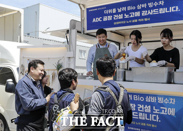 삼성바이오로직스(대표이사 존 림)가 장마와 무더위에도 공장 건설에 전념하고 있는 건설 협력사 기술인들을 격려하며 노사 공동으로 빙수차를 운영했다. 사진은 이규호 삼성바이오로직스 피플센터 센터장(사진 왼쪽)과 박재성 상생노동조합 위원장(왼쪽 첫번째)이 빙수차에 방문한 협력사 기술인들을 격려하는 모습. /삼성바이오로직스