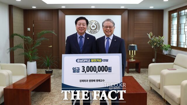 22일 충남대 염명배 명예교수(오른쪽)가 김정겸 총장을 방문해 발전기금 300만 원을 기부하고 있다. /충남대