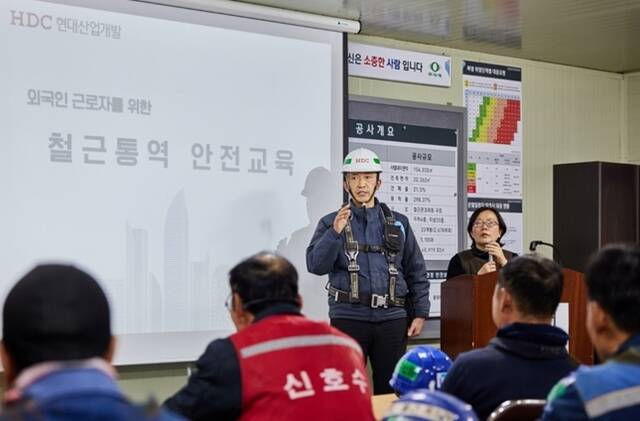 HDC현대산업개발 안전 담당자가 지난 2월 20일 잠실진주재건축현장에서 외국인 근로자들을 대상으로 전문 통역사를 활용한 전사적 차원의 안전교육을 하고 있다. /HDC현대산업개발