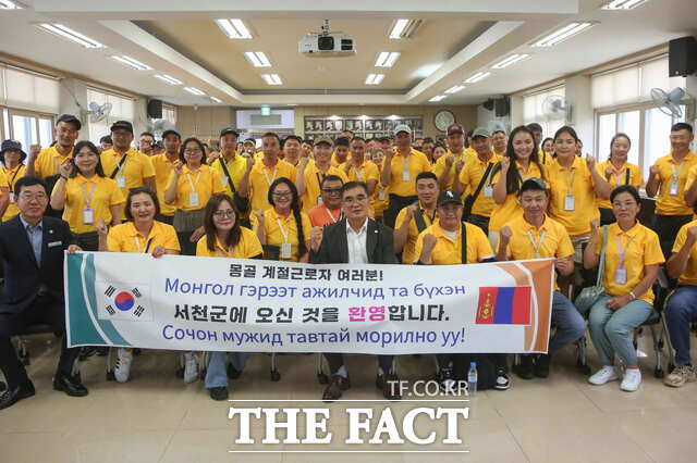 김기웅 서천군수(가운데)가 몽골에서 입국한 외국인 계절근로자들과 기념촬영을 하고 있다. / 서천군