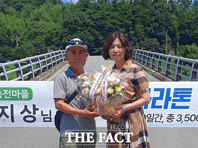 경남 함양군 휴천면 송전마을 원지상(77)씨가 미국 대륙 마라톤 횡단을 성공적으로 마무리하고 지난 1일 귀국했다.이선희 휴천면장이 원지상 씨에게 축하 꽃바구니를 전달하고 있다./함양군