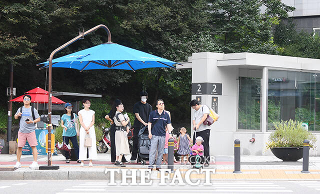 전국 대부분 지역에서 최고 체감온도가 35도 안팎으로 올라 찜통더위가 이어진 11일 오후 서울 은평구 구파발역 인근에서 시민들이 더위를 피하기 위해 그늘막 아래 대기하고 있다. /장윤석 기자