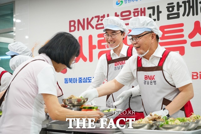 예경탁 경남은행장(가운데)과 홍남표 시장(오른쪽)이 진해서부노인종합복지관에서 사랑의 특식 배식 봉사활동을 하고 있다./경남은행