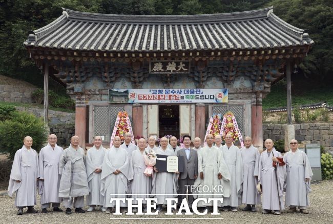 심덕섭 고창군수(앞줄 왼쪽 8번째)가 문수사에서 국가지정문화유산 보물로 승격된 ‘고창 문수사 대웅전’의 보물 지정서 전달식을 개최한 후 관계자들과 기념촬영을 하고 있다./고창군