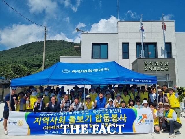 여수21세기로타리클럽 회원들이 지난 1일 전남 여수시 화양면 장척마을에서 낡고 노후한 대문 페인트 칠하기 봉사활동을 마친 뒤 기념사진을 찍고 있다./여수21세기로타리클럽