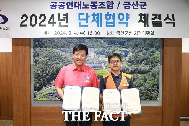 박범인 금산군수(왼쪽)와 김민재 공공연대노동조합 충남세종본부장이 4일 군청 상황실에서 단체협약을 체결하고 기념촬영을 하고 있다. /금산군