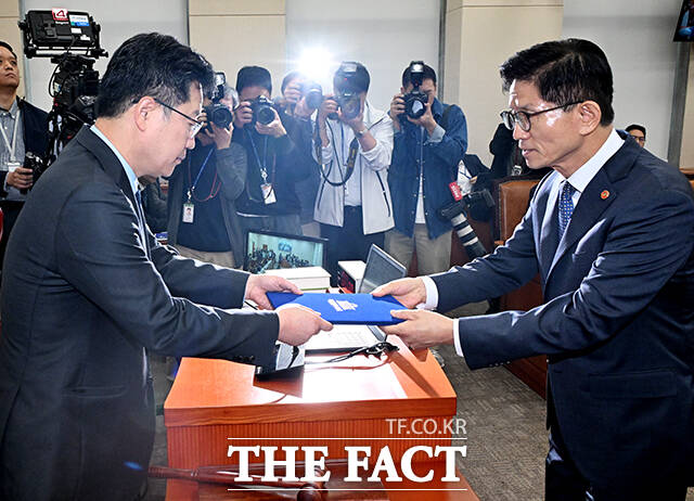안호영 위원장(왼쪽)에게 선서문 제출하는 김문수 고용노동부 장관(오른쪽).